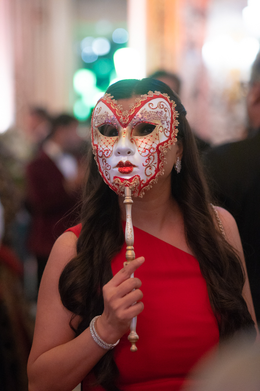 wedding guest holding a venician mask in hotel de paris monaco