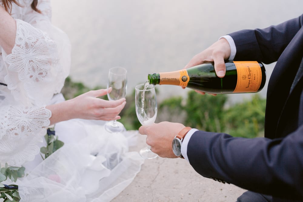 wedding bidegrooms cheersing with a bottle of champagne in provence